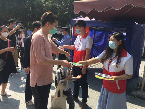 (图:"昌华前哨"志愿者在测温岗点测温并派发宣传单张)