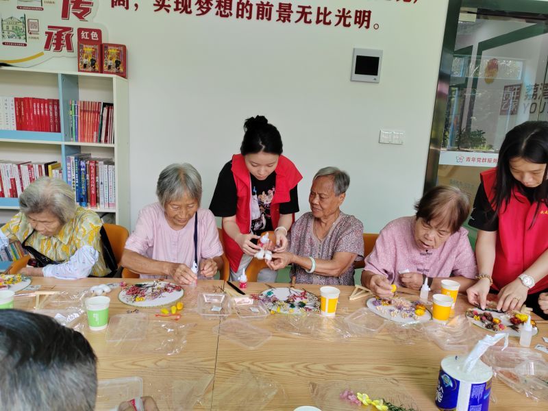 工作人员协助居民完成团扇制作.jpg