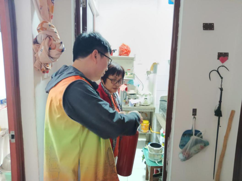 工作人员正在讲解烟感报警器和灭火器的使用方法.png