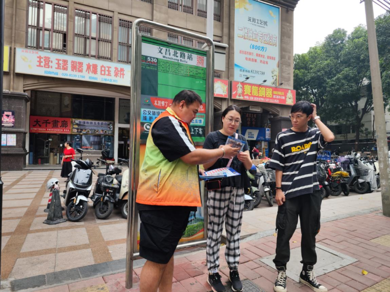 社区工作人员在文昌北路公交站向居民群众派发禁毒、防诈骗资料.png