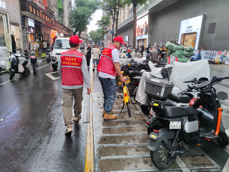 图：“红棉老兵”志愿者搬动随意停放的共享单车.jpg