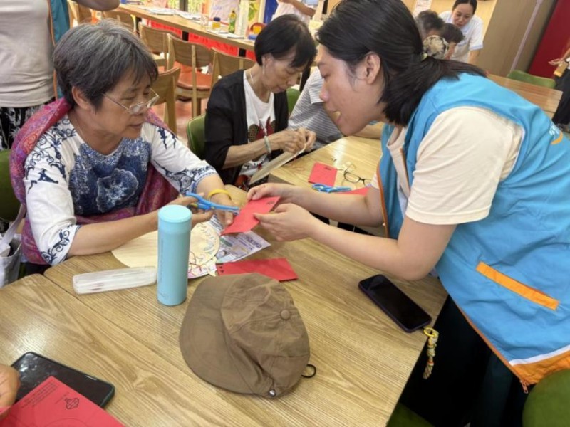 图：工作人员指导居民完成剪纸的细节部分.jpg