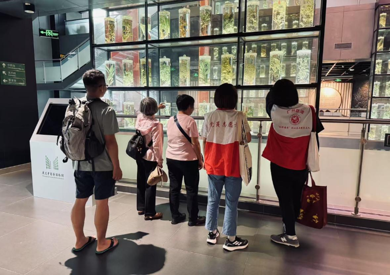 图：居民群众和志愿者们认真探讨馆内陈列的展品.png