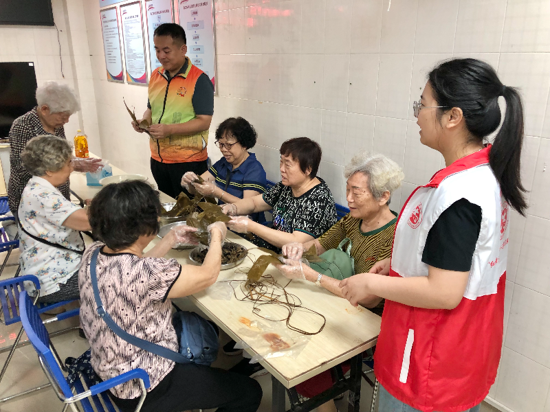 图：居民围坐一起动手包粽子.jpg