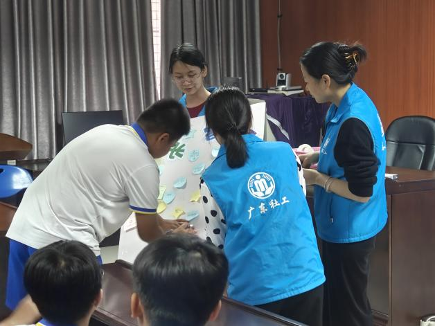 图：同学们把成长寄语贴到板子上.png